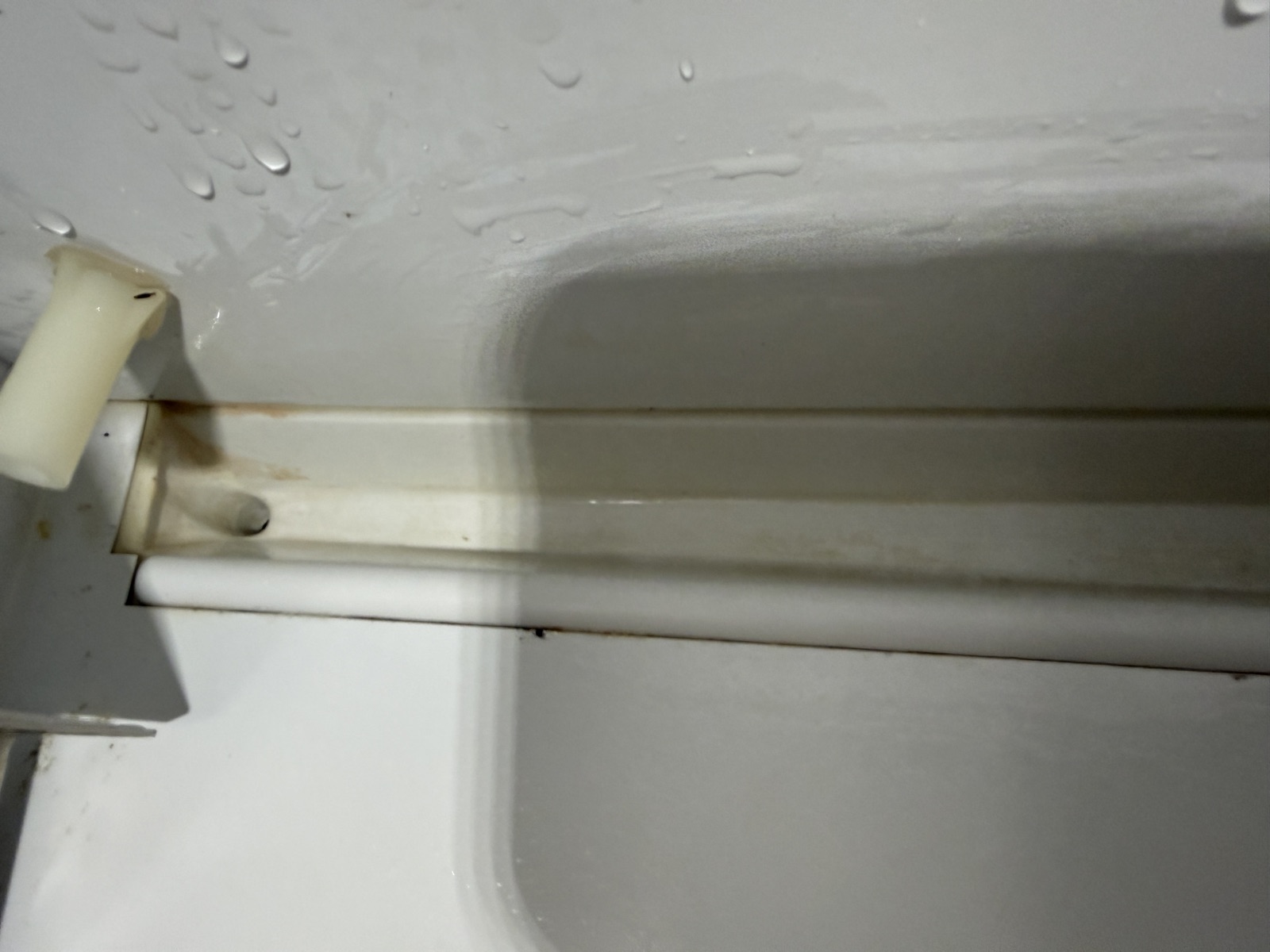 Drain channel running down the back corner of the Sub-Zero refrigerator compartment
