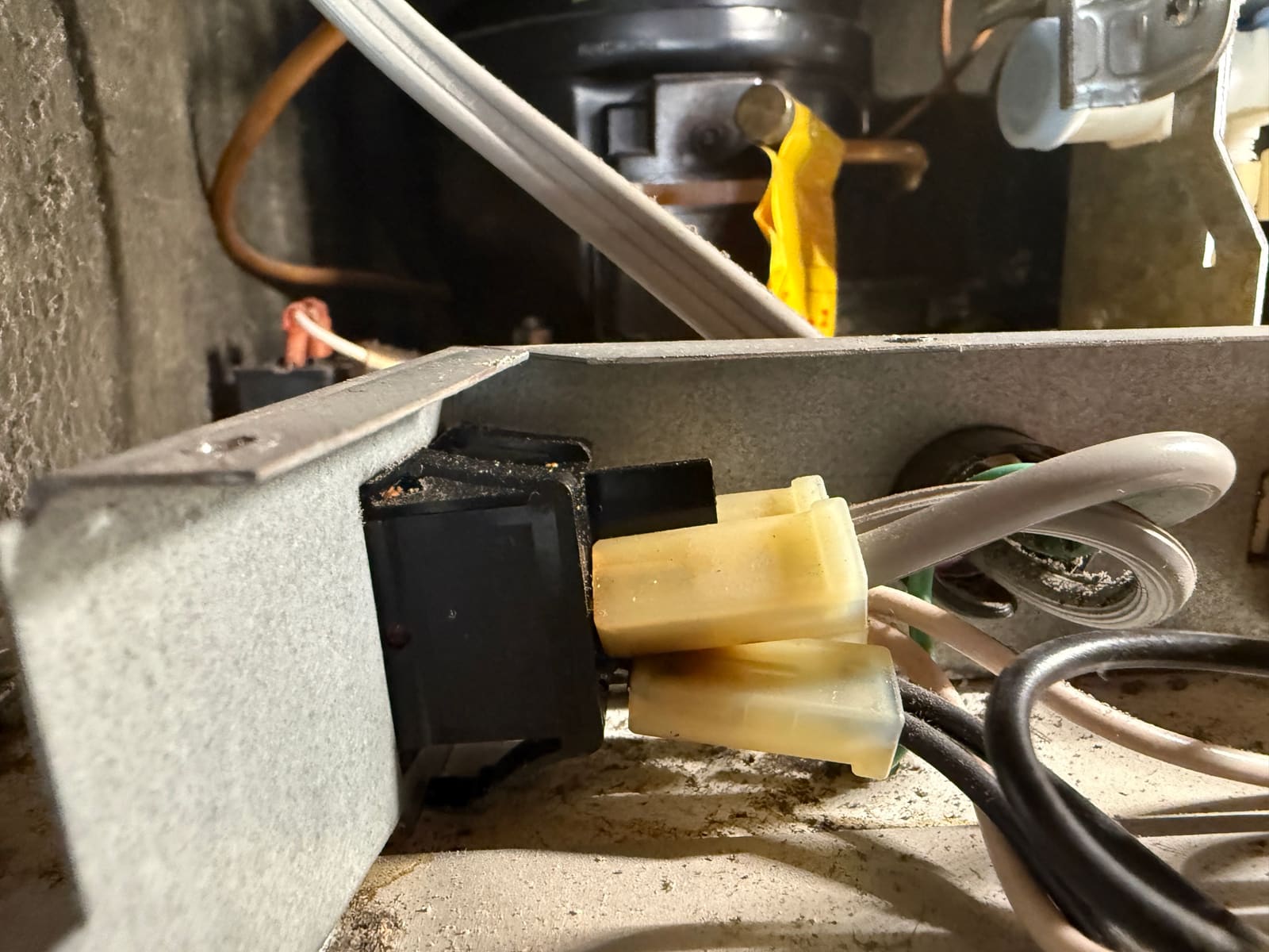 Burned black power switch on its bracket with scorched yellow connectors plugged into it