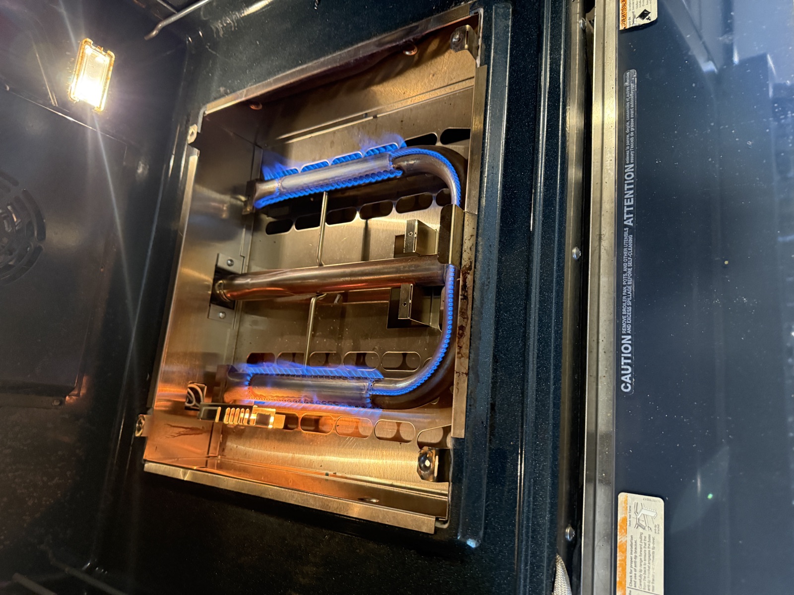 Oven burner lit with blue flame inside the Thermador range after the new igniter was installed
