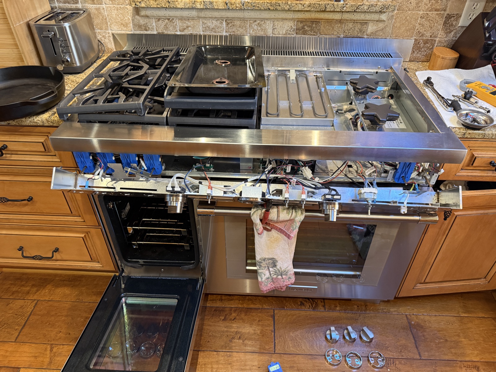 Thermador range with the front control panel removed and the knobs laid out on the floor