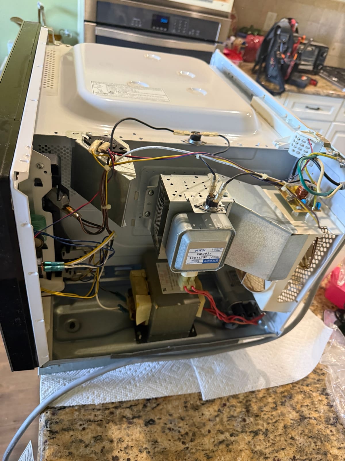Inside a Whirlpool microwave: magnetron, high-voltage transformer, fan, wiring and door switch area