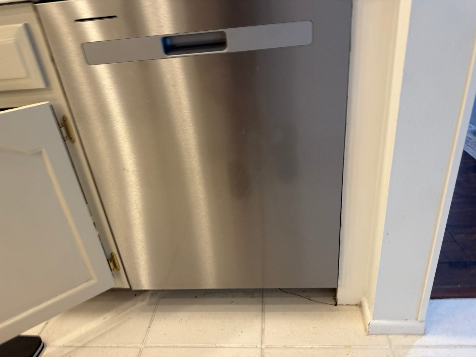 Stainless Whirlpool dishwasher built into white cabinets in the Countryside North Ridge area of Clearwater