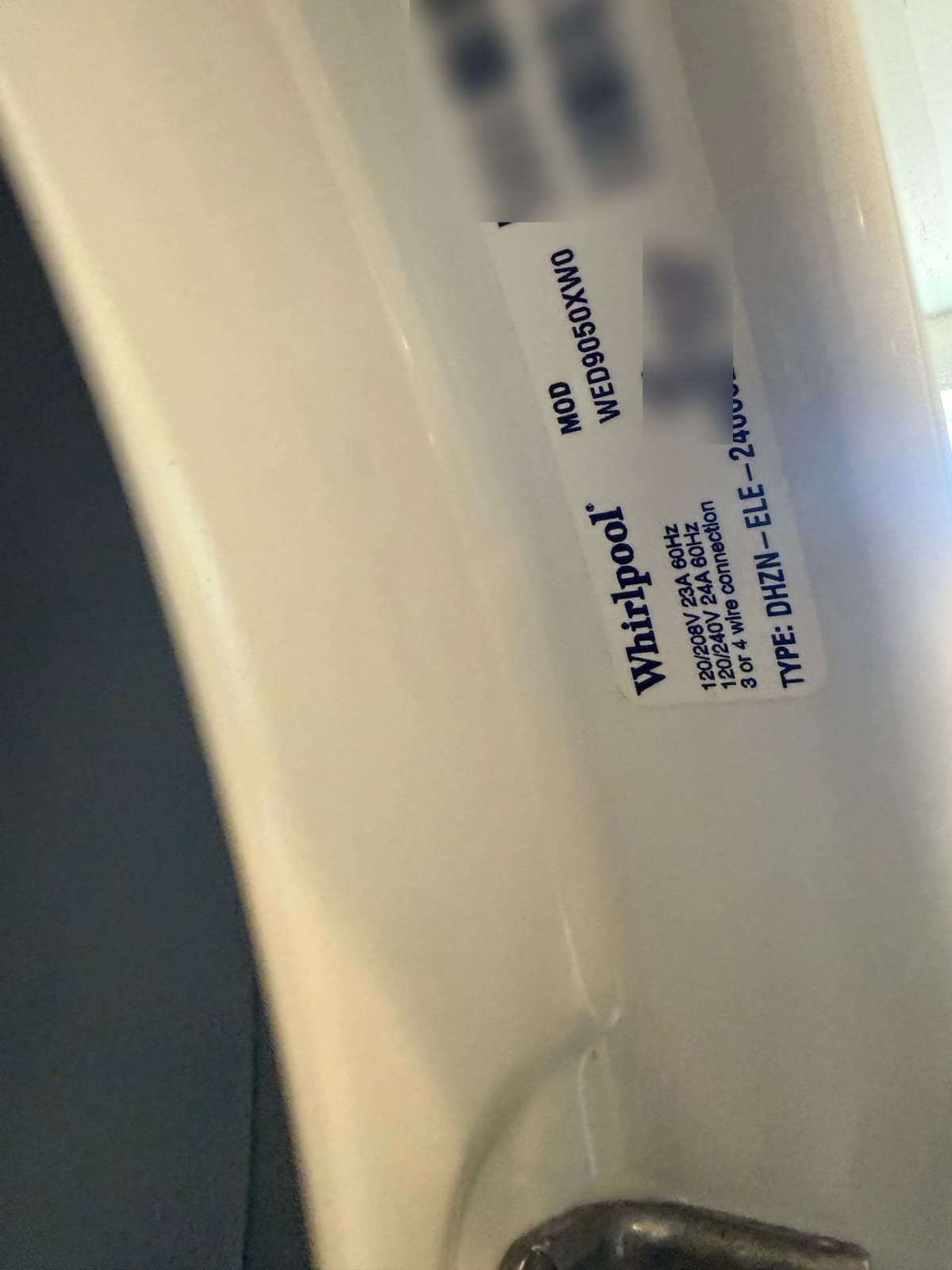 Whirlpool dryer data plate with the model number WED9050XW0 readable; serial number and barcodes blurred