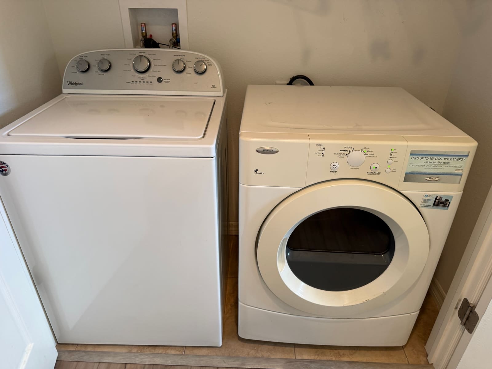 Whirlpool front-load AccuDry electric dryer next to a Whirlpool top-load washer in a Safety Harbor laundry closet