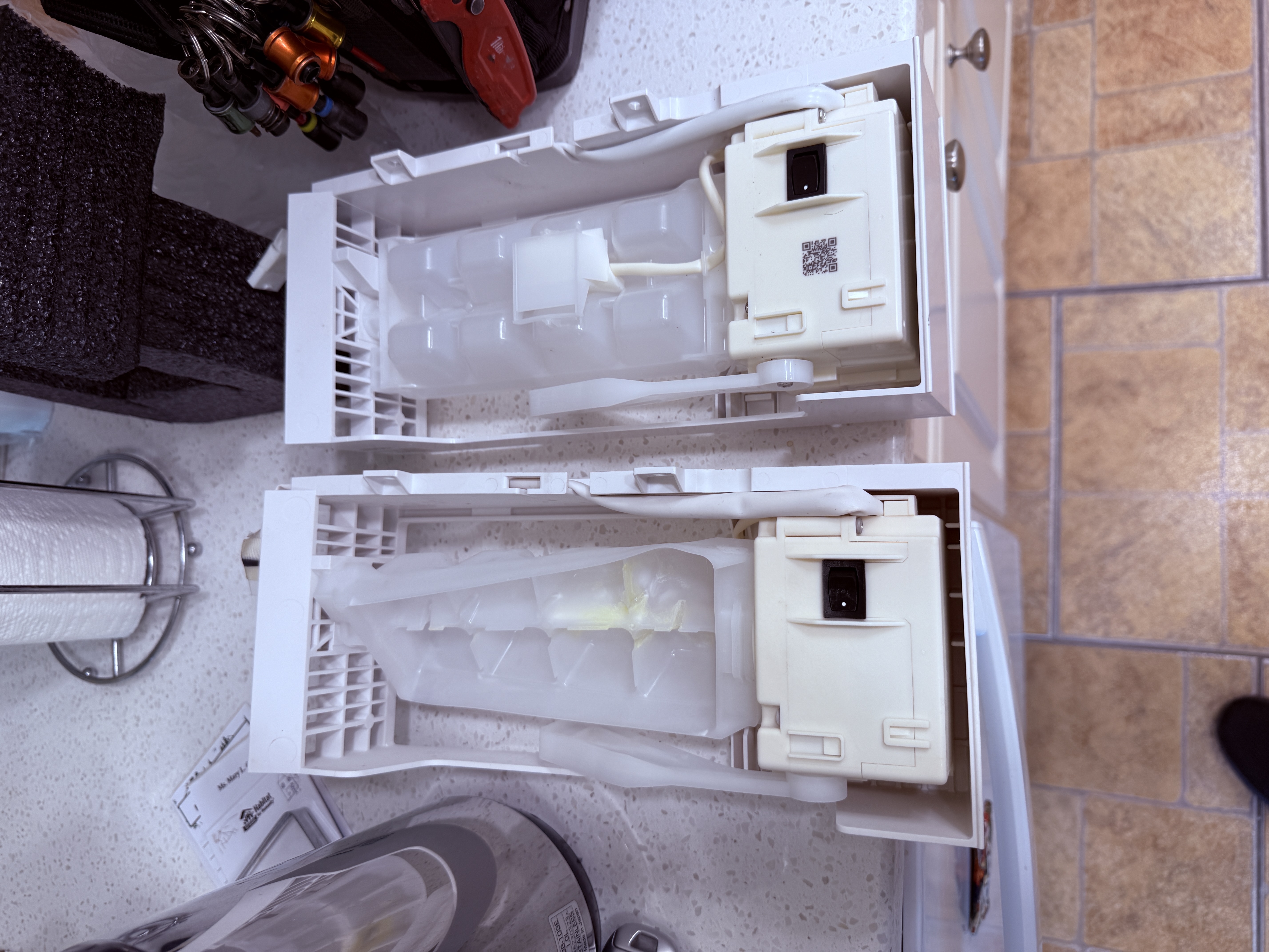 Old and new icemaker assemblies side by side for a Whirlpool refrigerator