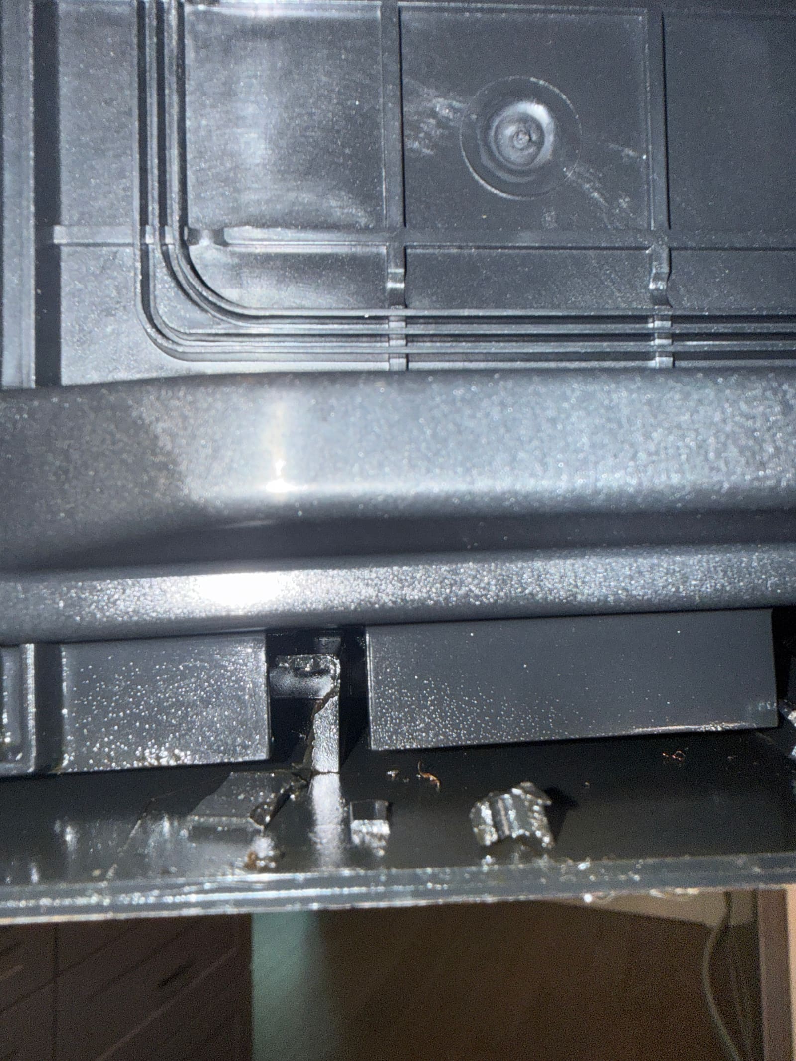 Cracked mounting point on the microwave's door frame near the touch control panel
