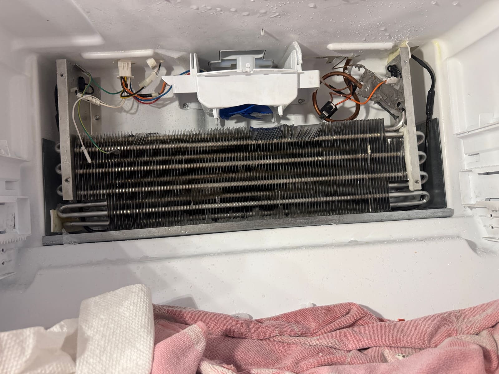 Whirlpool freezer evaporator coil fully defrosted with the fan and wiring visible