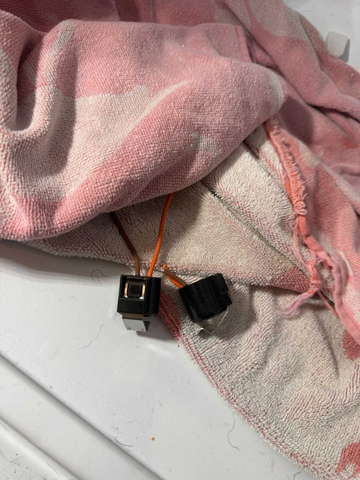 Old and new defrost sensors with their brown and orange wires