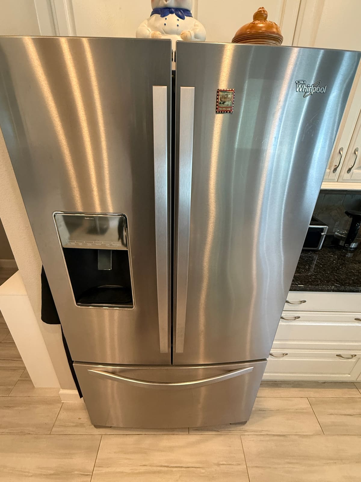 Whirlpool stainless French door refrigerator with an ice and water dispenser in a kitchen in the Myrtle Point neighborhood of Palm Harbor