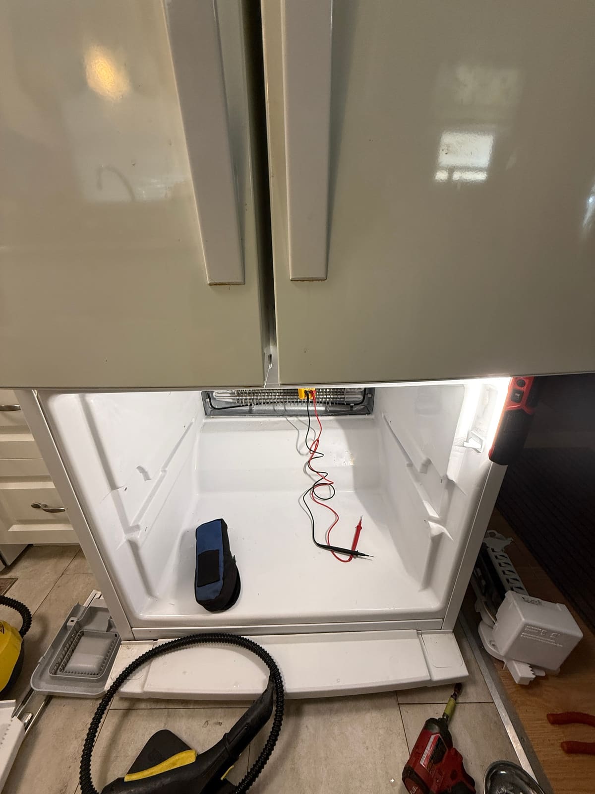 Whirlpool French door refrigerator with the bottom freezer drawer removed and a meter connected to the evaporator coil, in the Amber Glades community of Safety Harbor