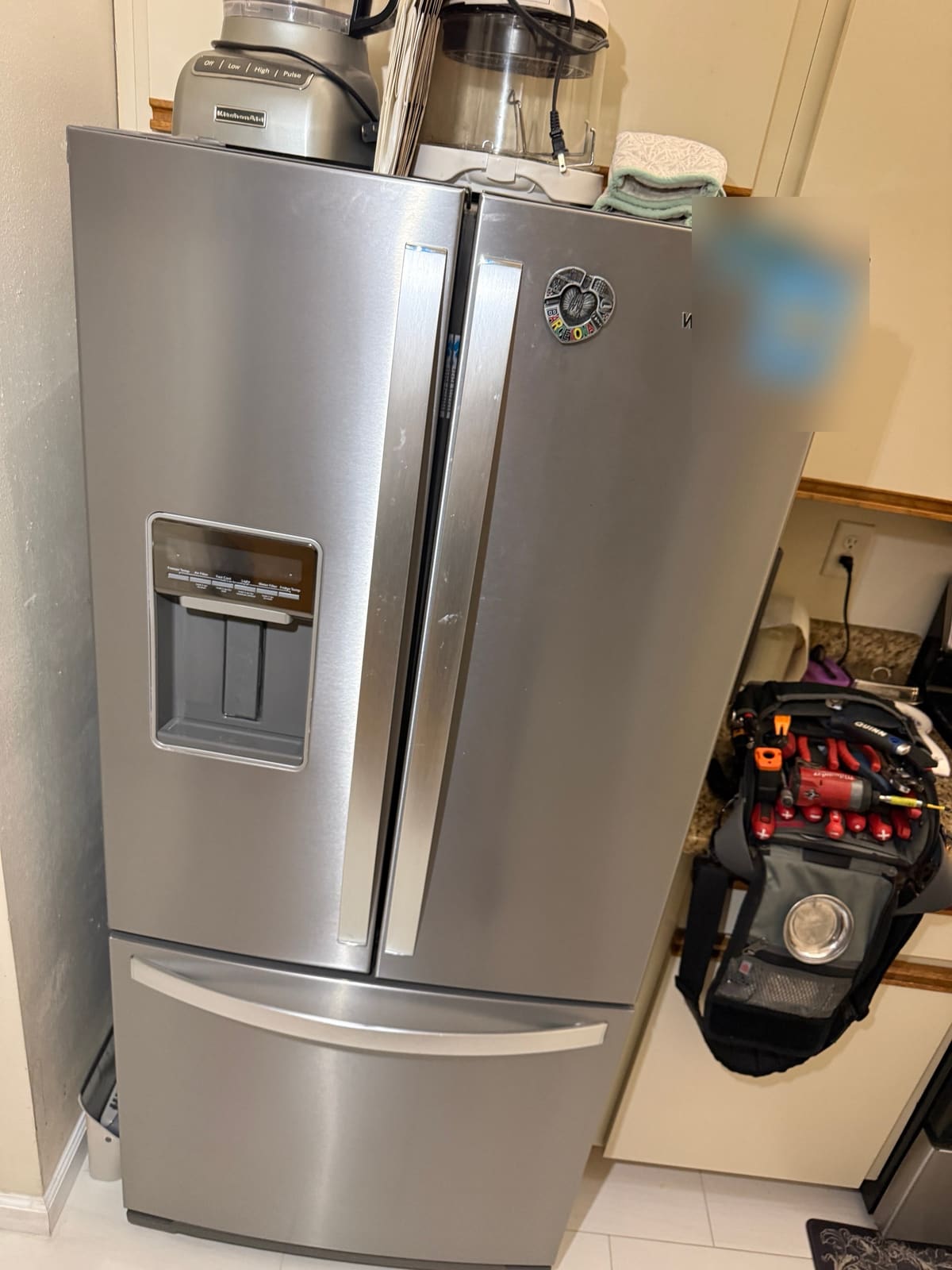 Stainless steel Whirlpool French door refrigerator with a door water dispenser and bottom freezer drawer