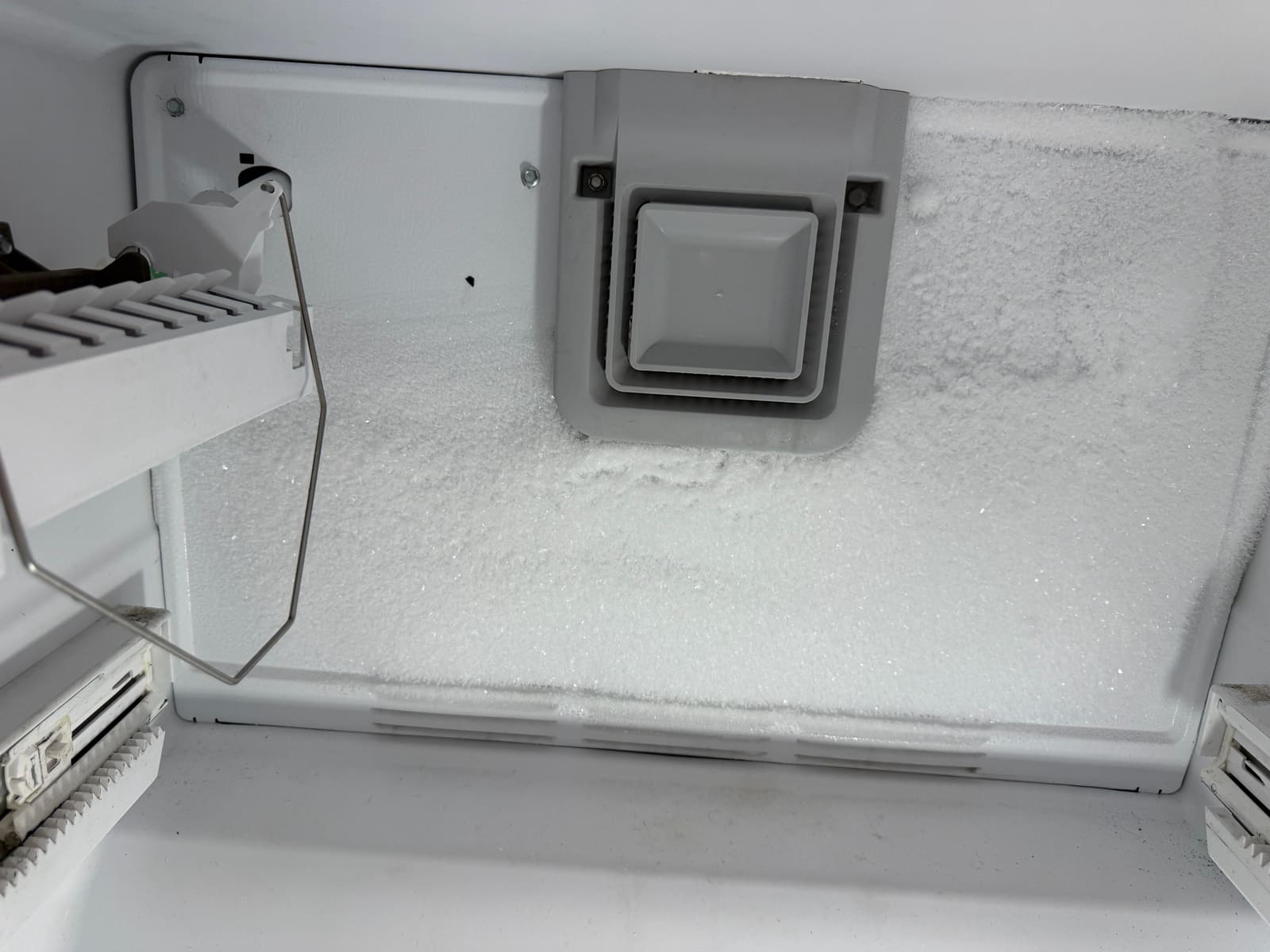 Thick frost covering the back panel of the Whirlpool freezer next to the ice maker