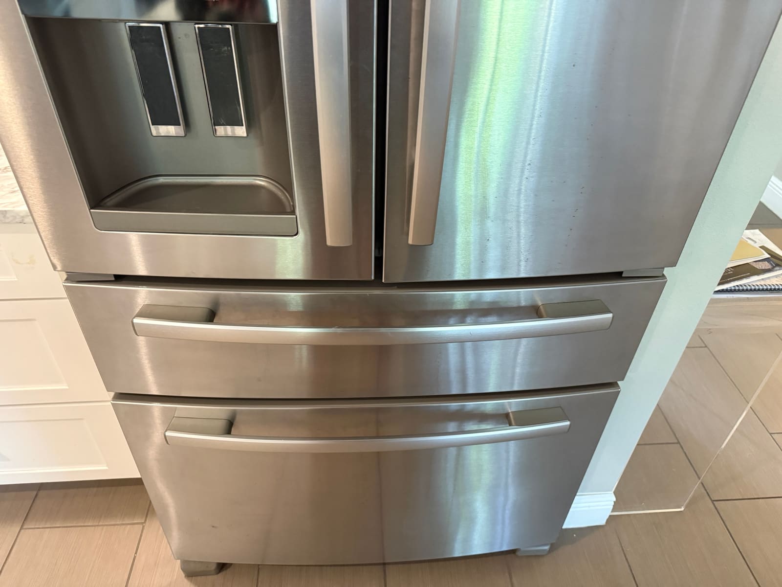Whirlpool stainless French door refrigerator with a water and ice dispenser in a kitchen in Westchase