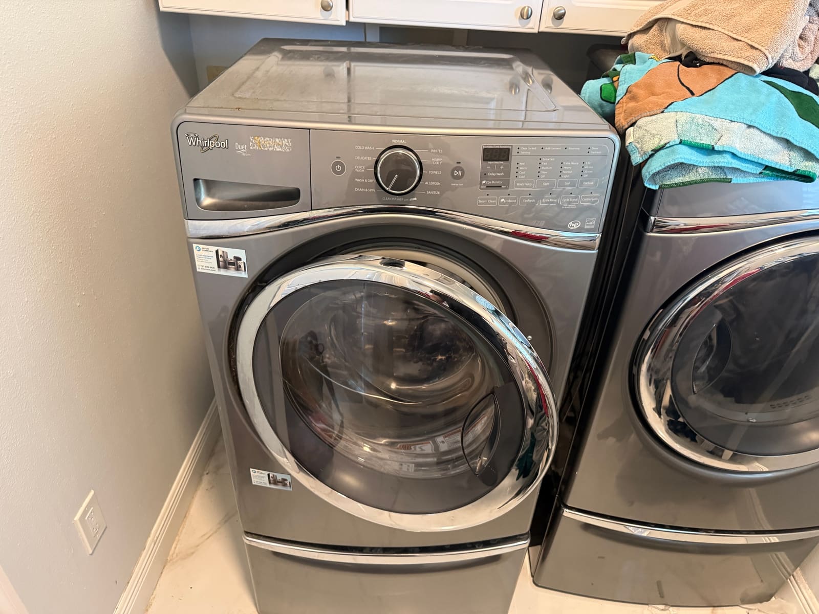 Whirlpool Duet front-load washer on a pedestal in a laundry room in East Lake, Palm Harbor