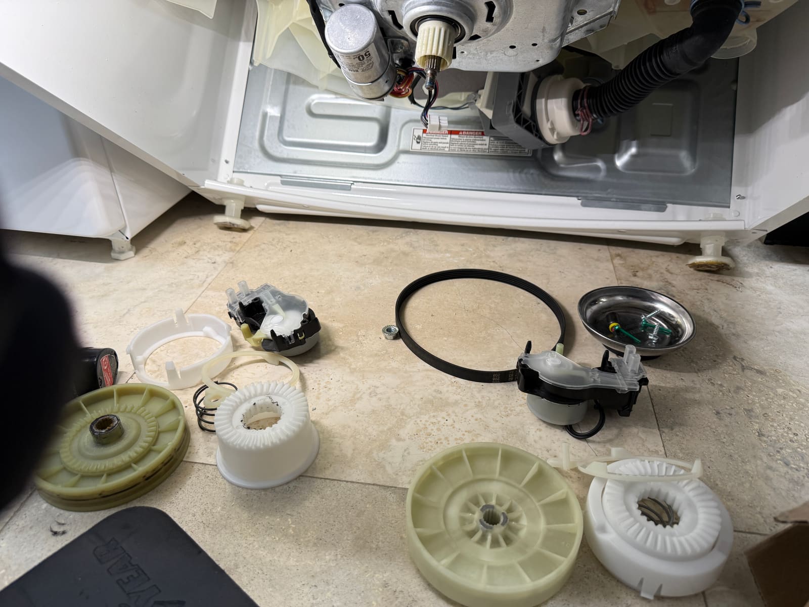Worn cam and shifter components removed from the Whirlpool washer's transmission