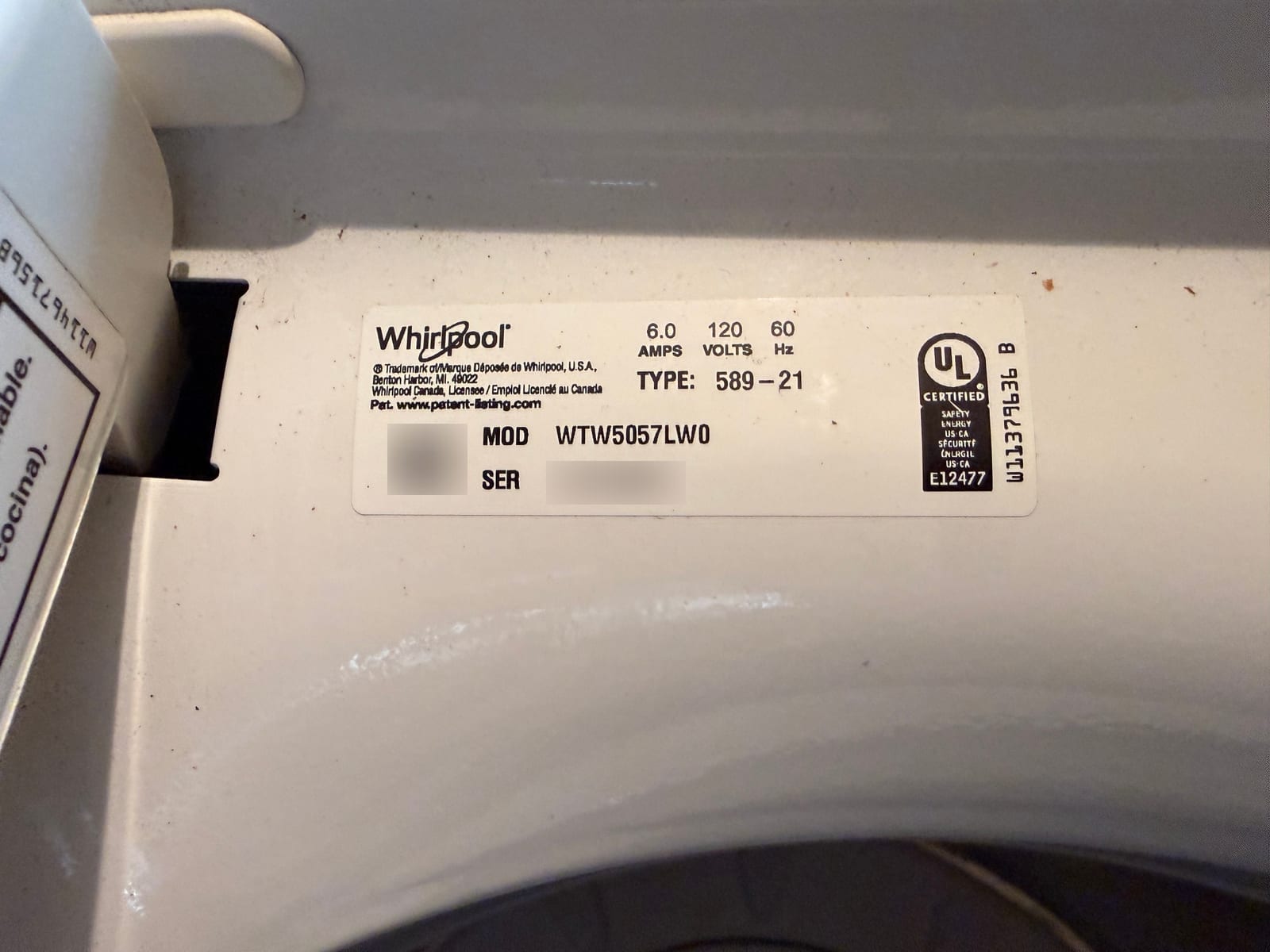 Whirlpool washer data plate with model WTW5057LW0 readable; serial number and barcode blurred