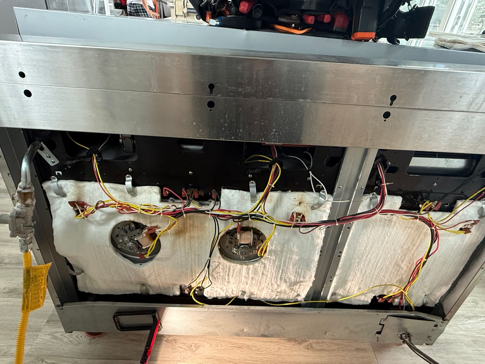 Rear service panel open on a ZLine dual-fuel range showing the bake element wiring and insulation