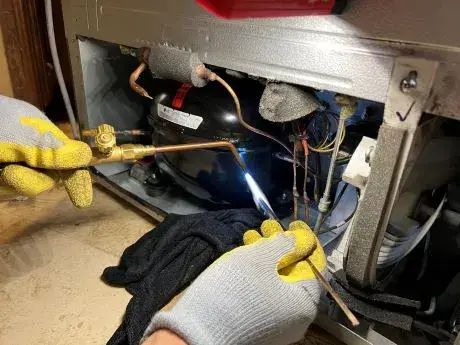 Technician repairing a household appliance in a Tampa home