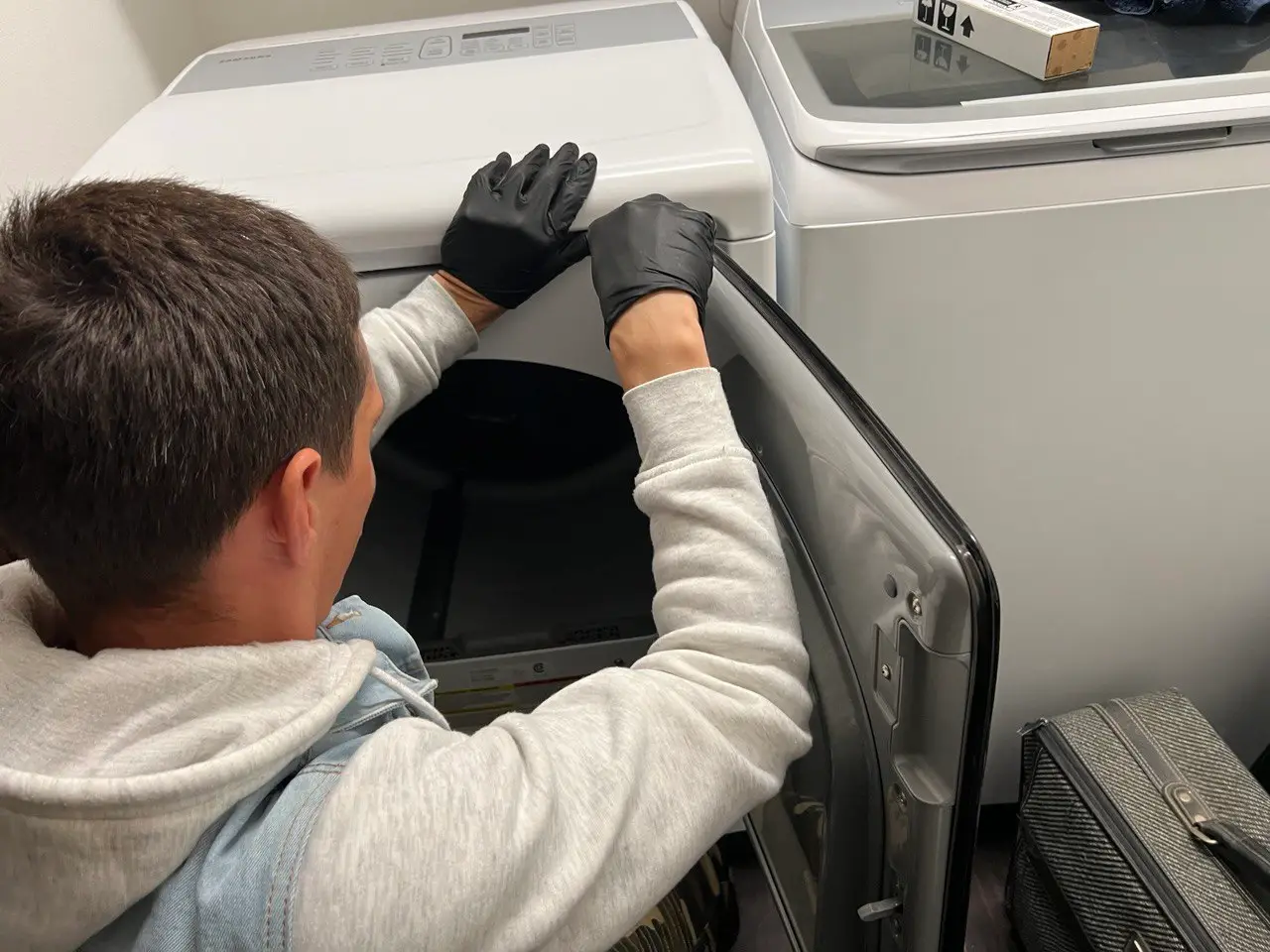 Technician repairing a household appliance in a Dunedin home