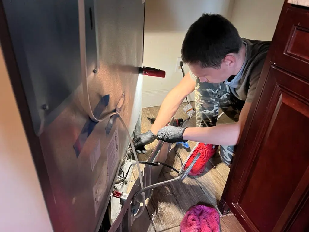 Technician repairing an LG refrigerator in a Tampa Bay home